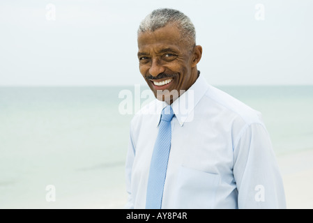 Businessman smiling at camera, sea in background Stock Photo