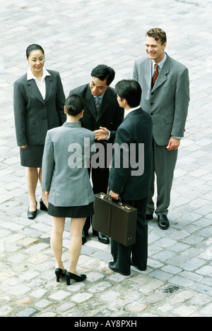 Group of professionals standing together, man and woman shaking hands, high angle view Stock Photo