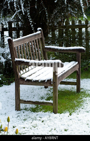 Snow Covered Wooden Garden Seat English Country Garden in Winter Stock Photo