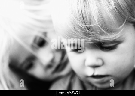 Girl leaning her head on younger brother's shoulder, both looking down, portrait, close-up Stock Photo
