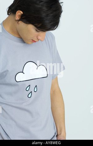 Young man wearing tee-shirt printed with cloud and raindrops, head down Stock Photo