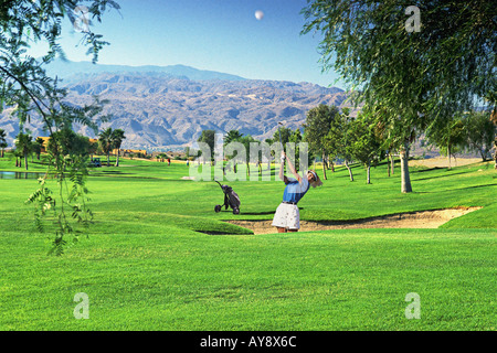 Palm Springs California CA Desert Princess  Country Club Golf  Course, Cart, Woman,  30, 40's single hitting ball out of sand Stock Photo