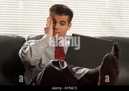 young business man on sofa with laptop Stock Photo