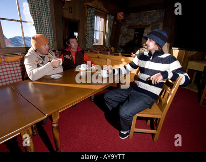 Friends sit talking in bar restaurant in Tignes, France Stock Photo