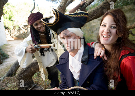 Armed pirates holding a navy officer as hostage and threatening him with weapons Stock Photo