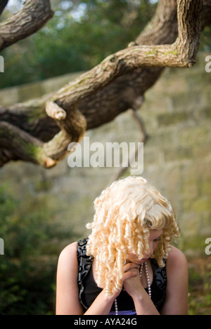 View of a frightened princess in a purple gown lost in the woods Stock Photo