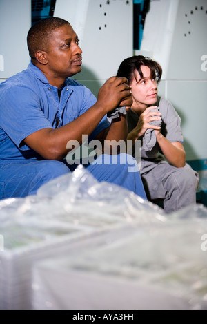 Portrait of a man and a woman next to some machinery Stock Photo