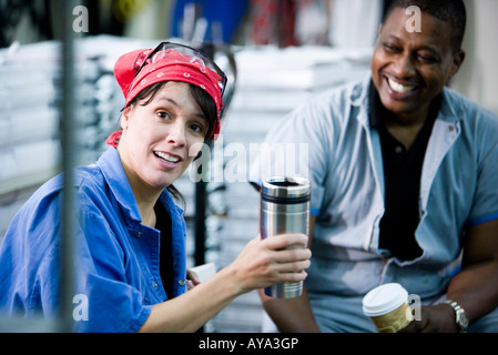 Workers in coveralls having a coffee break Stock Photo