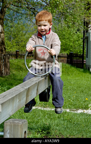 Boy 5 years old on a teeter totter Stock Photo