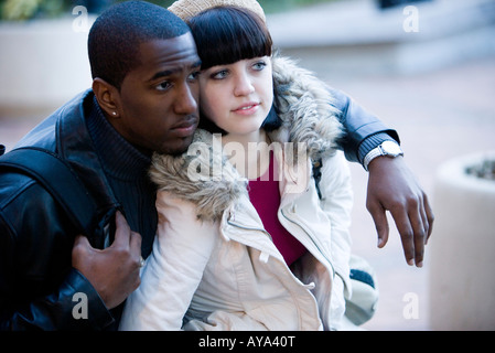 Close-up of a young interracial couple wearing coats Stock Photo