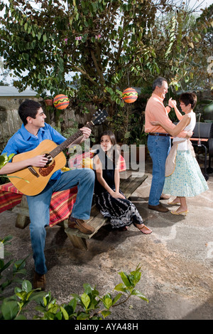 A Mexican-American family playing music and dancing in the backyard of their house Stock Photo
