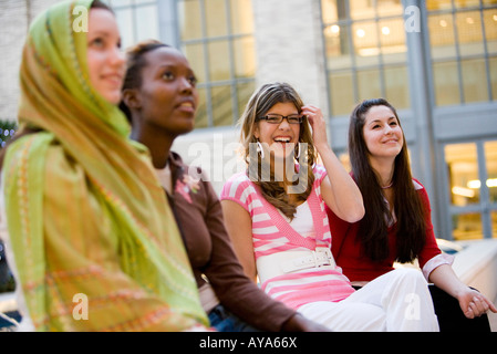 Low-angle view of women sitting together outside a building Stock Photo