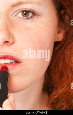 Young woman applies lipstick Stock Photo