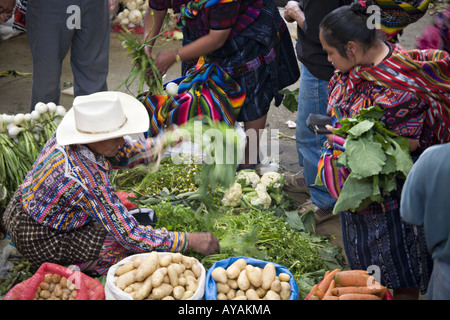 GUATEMALA CHICHICASTENANGO Local Quiche Mayan vendors in traditional dress sell vegetables in the market Stock Photo