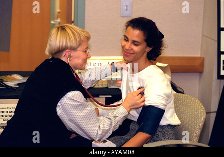 Student examined by doctor age 21 and 50 Biomedical Engineering open house. University of Minnesota Minneapolis Minnesota USA Stock Photo