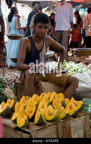 Young man selling fresh melon slices at the market in Negombo, near Colombo, Sri Lanka. Stock Photo