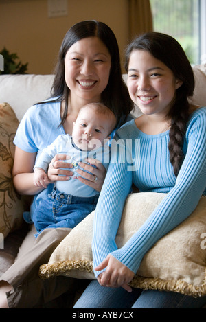 Portrait of an Asian mother with her Asian-Caucasian teenage daughter and infant boy Stock Photo