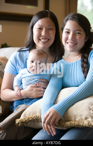 Portrait of an Asian mother with her Asian-Caucasian teenage daughter and infant boy Stock Photo