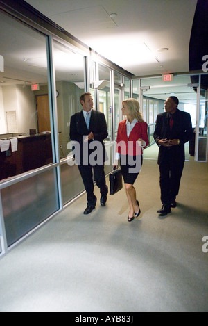 Business people walking down office hallway and lobby and conversing Stock Photo