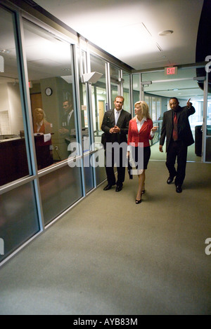 Business people walking down office hallway and lobby and conversing Stock Photo
