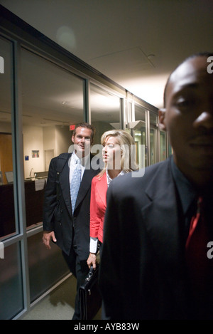 Business people walking down office hallway and lobby and conversing Stock Photo