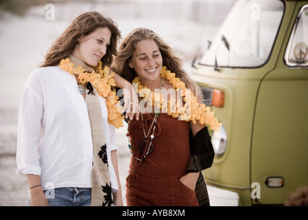 Two young women standing next to van Stock Photo