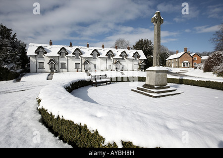 The thatched cottages and war memorial on the green covered in snow Warter East Yorkshire England UK Stock Photo