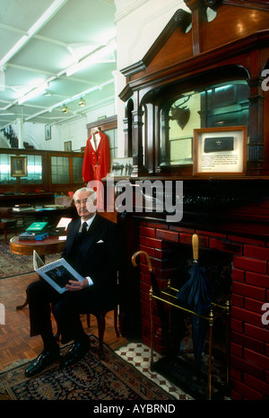 Savile Row tailor taking a break in the showroom interior of Hogg JB Johnstone London England Stock Photo