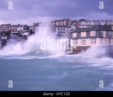 Stormy sea at high tide crashing over harbour wall onto harbour side houses St Ives Penwith West Cornwall South West England UK Stock Photo