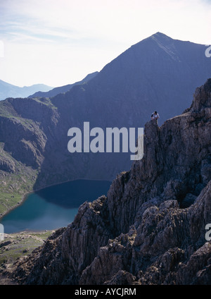 Climber on Crib y Ddysgl with Mt Snowdon in shadow overlooking Lake Glaslyn behind Snowdonia National Park North Wales Stock Photo