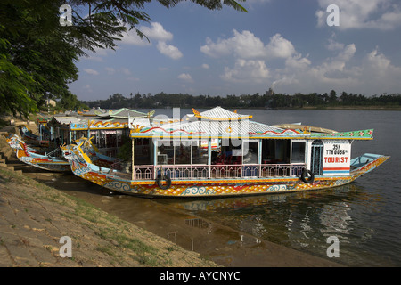 Tourist boats pulled up on Perfume River below Thien Mu Pagoda tower Hue central Vietnam Stock Photo