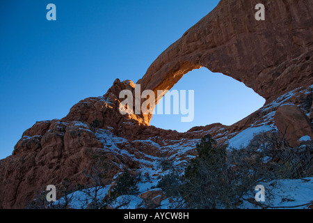 Sunset glow on South Window from the backside in winter snow at Arches National Park Stock Photo