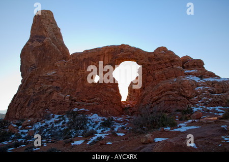 Sunset glow on Turret Arch with winter snow in Arches National Park Stock Photo