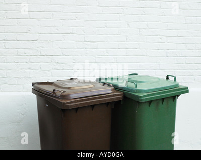 Rubbish bins against white brick wall Stock Photo