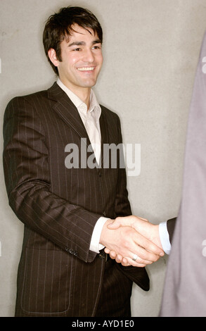 Two businessmen stand shaking hands in an office, side view Stock Photo ...