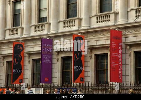 Pedestrians passing coloured banners outside the Royal Academy of Arts in Piccadilly London England Stock Photo