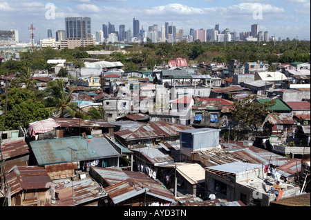 Manila, The Philippines: Slum huts in front of the skyline of the bank district Makati Stock Photo