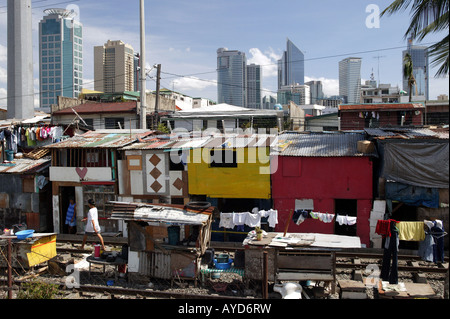 Manila, The Philippines: Slum huts in front of the skyline of the bank district Makati Stock Photo