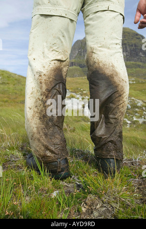 walking trousers covered in peat mud, Scotland UK Stock Photo