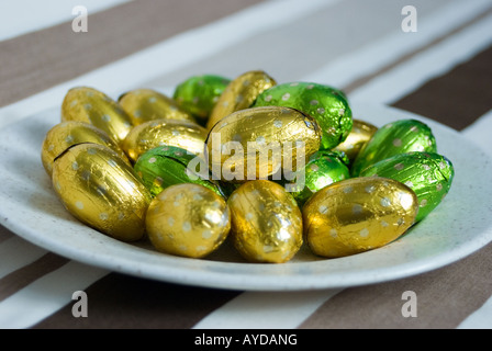 Green and Gold foil covered Easter Eggs on a plate Stock Photo