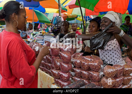 African Gabonese woman buying nuts from a stallholder, Mont-Bouet Market, largest market in Libreville, Gabon Stock Photo