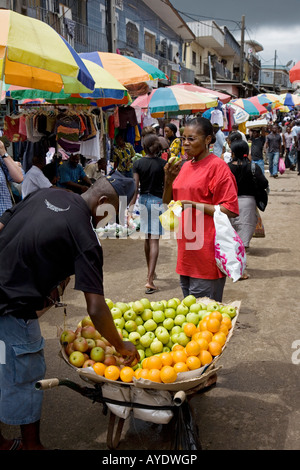 African Gabonese woman buying apples from a street hawker, Mont-Bouet Market, largest market in Libreville, Gabon Stock Photo