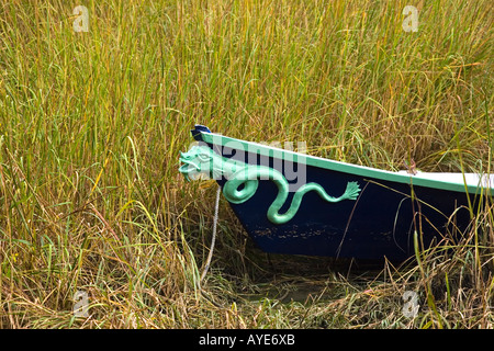 Carving of a snake on the hull of a hand crafted wooden dory. Stock Photo