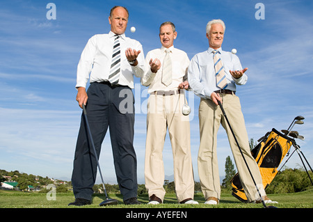 businessmen throwing golf balls Stock Photo
