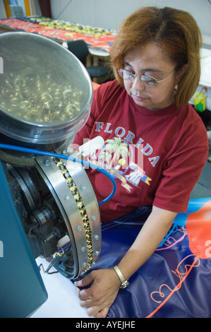Woman operating machine inserting grommets in banners Stock Photo