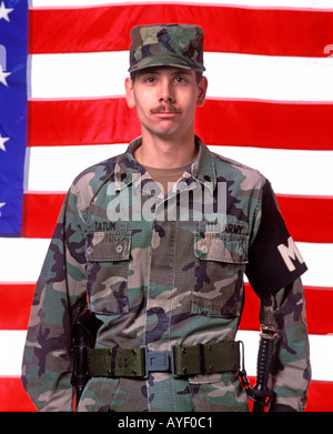 US military policeman in front of flag Stock Photo