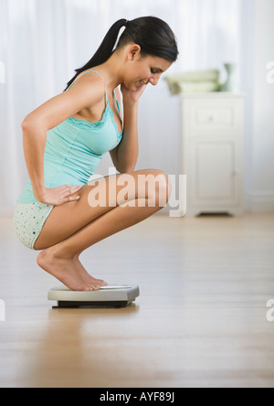 Woman crouching on scale Stock Photo