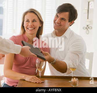 Couple paying at restaurant Stock Photo