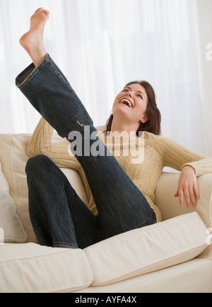 Woman kicking leg on sofa Stock Photo