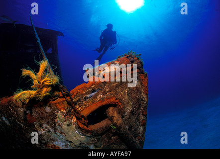 Beautiful colour Underwater Shipwreck covered in bright coral, brilliant sunburst and silhouetted Diver background New Providence Island, Bahamas Stock Photo